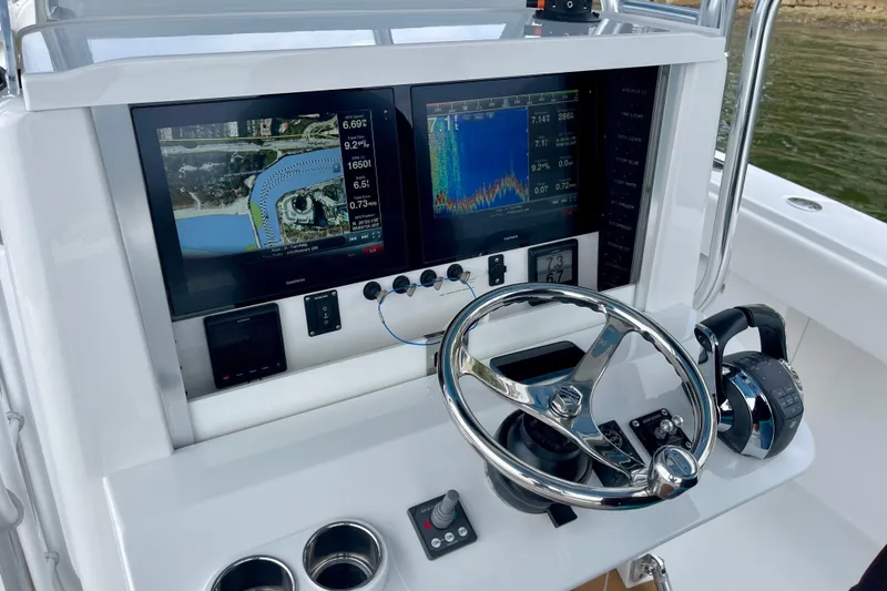 Slide: The Image of Control panel of a 2016 Bahama 41 boat with navigation screens and steering wheel. - 11