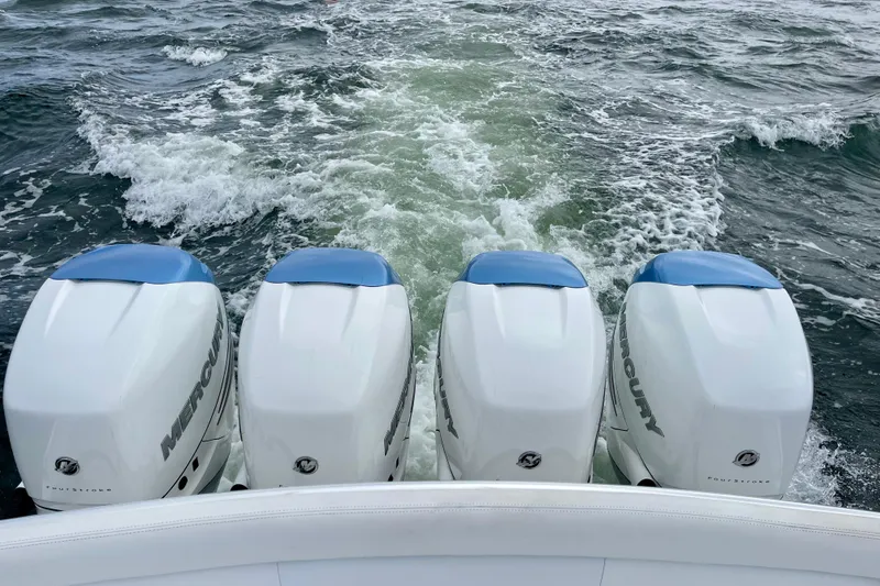 Slide: The Image of Four Mercury outboard engines on a 2016 Bahama 41 boat cruising through water. - 14