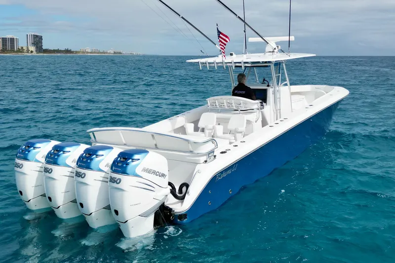 Slide: The Image of 2016 Bahama 41 boat with four Mercury engines cruising on clear blue water. - 4