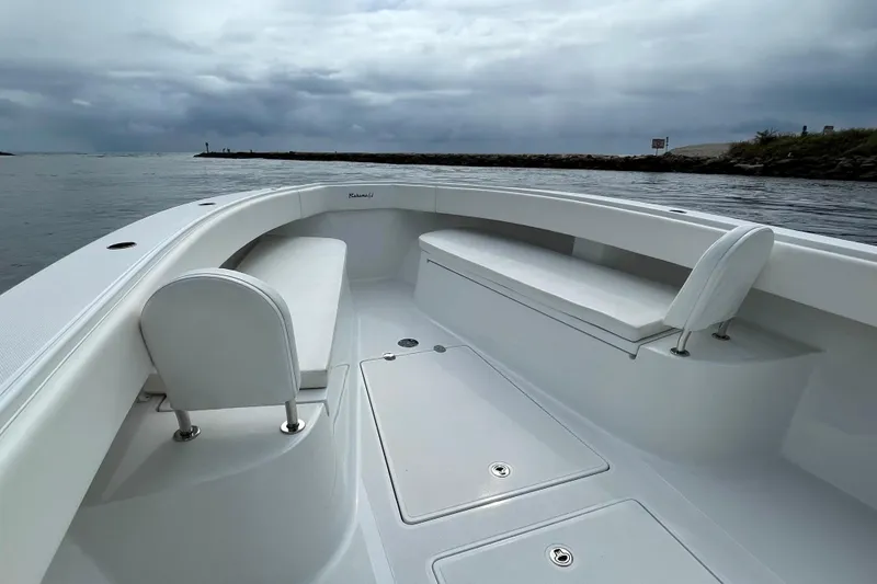 Slide: The Image of 2016 Bahama 41 boat interior with white seating, under cloudy skies near a shoreline. - 6