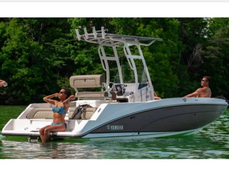Slide: The Image of 2022 Yamaha 210 FSH Sport boat on a lake with people. - 5