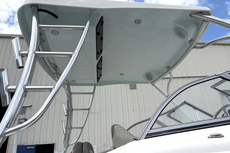 Slide: The Image of 2024 Key West 239 DFS boat with stainless steel ladder and canopy, docked near a building. - 14
