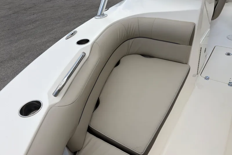 Slide: The Image of 2024 Key West 239 DFS boat interior with beige cushioned seating and stainless steel cup holders. - 18