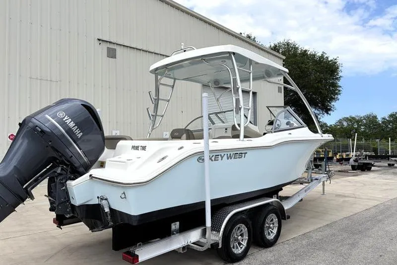Slide: The Image of 2024 Key West 239 DFS boat on trailer with Yamaha engine, parked outdoors. - 2