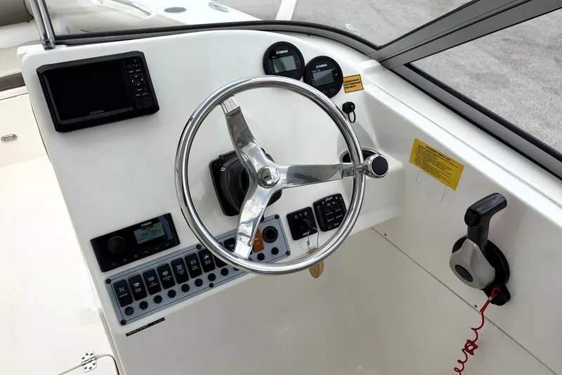 Slide: The Image of 2024 Key West 239 DFS boat dashboard with steering wheel and control panel. - 23