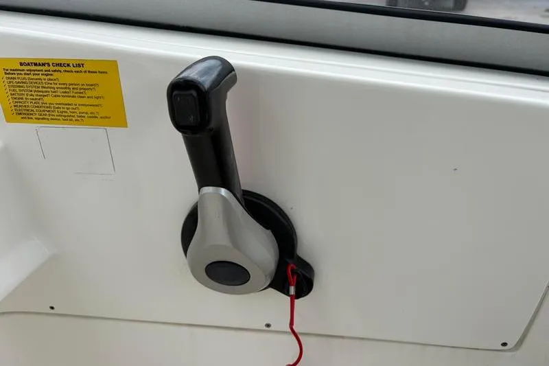 Slide: The Image of Throttle control lever on 2024 Key West 239 DFS boat dashboard with safety checklist. - 26