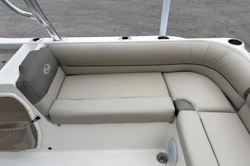 Slide: The Image of 2024 Key West 239 DFS boat interior with beige cushioned seating and cup holders. - 34