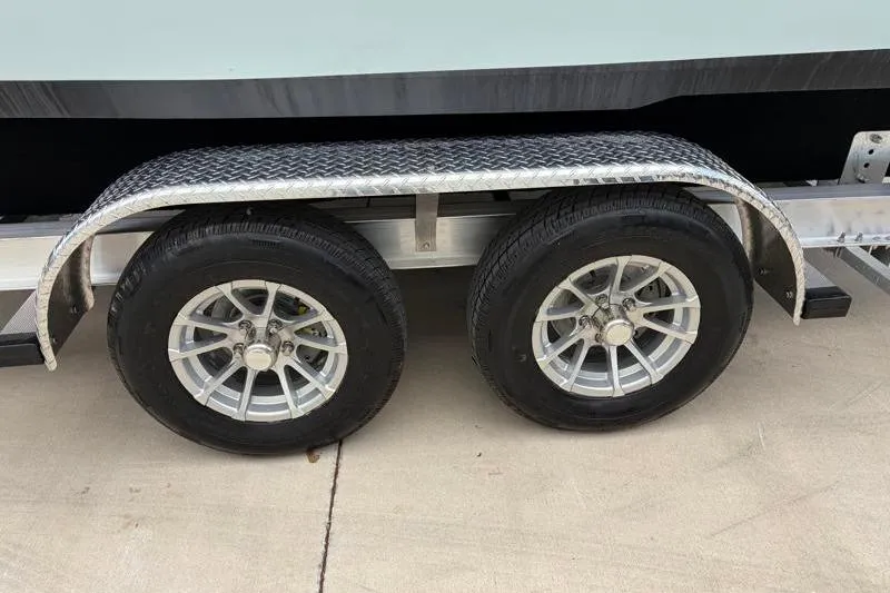 Slide: The Image of Trailer wheels of a 2024 Key West 239 DFS boat on a concrete surface. - 42