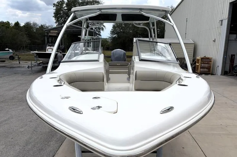 Slide: The Image of 2024 Key West 239 DFS boat with open bow seating, docked near a warehouse. - 6