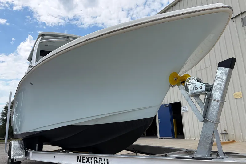 Slide: The Image of 2024 Key West 239 DFS boat on trailer, viewed from below against a cloudy sky. - 9