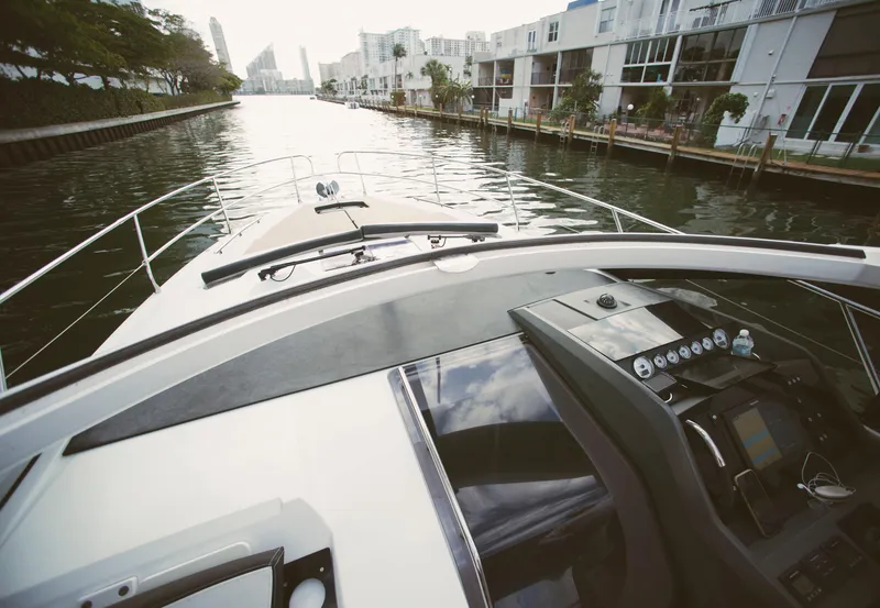 Slide: The Image of 2017 Jeanneau Leader 40 yacht navigating urban waterway, modern dashboard visible. - 41