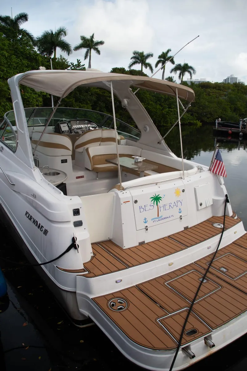 Slide: The Image of 2005 Four Winns 378 Vista boat docked with American flag, tropical backdrop. - 15
