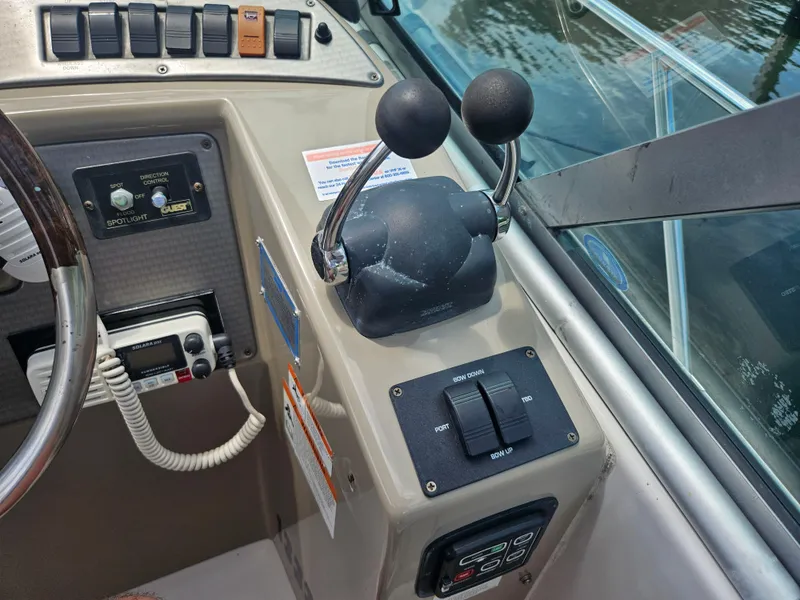 Slide: The Image of Control panel of a 2005 Four Winns 378 Vista boat, featuring throttle levers and navigation equipment. - 20