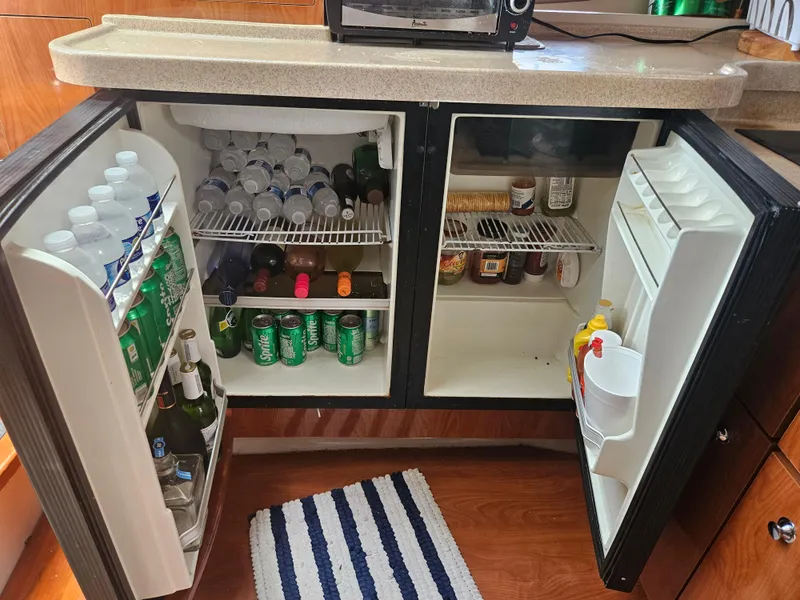 Slide: The Image of Mini fridge stocked with drinks and condiments in a 2005 Four Winns 378 Vista boat. - 37