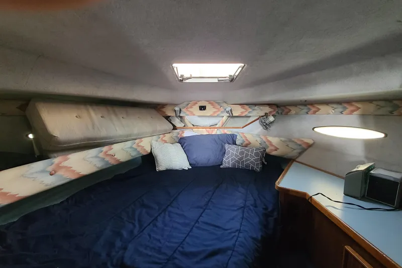 Slide: The Image of Interior cabin of 1987 Sea Ray 300 Sundancer with cozy bedding and patterned decor. - 13