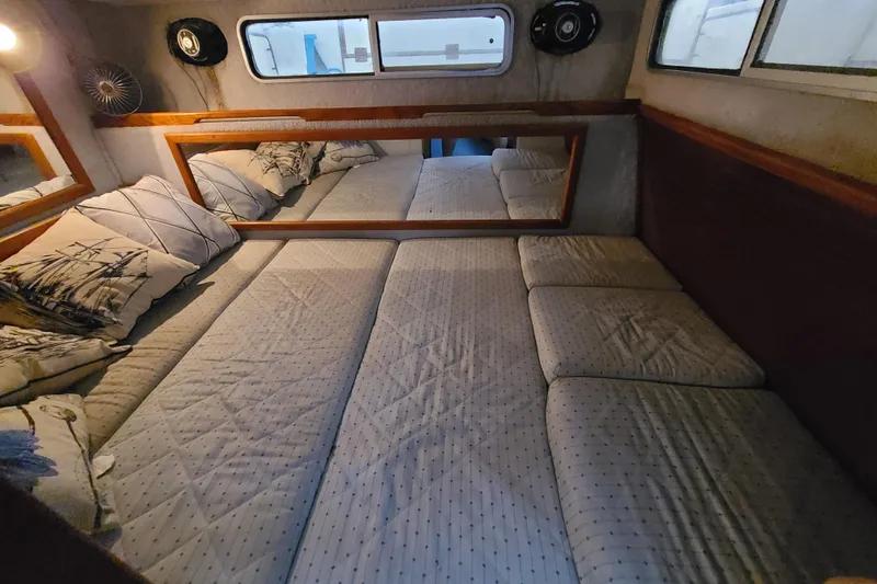 Slide: The Image of Interior cabin of 1987 Sea Ray 300 Sundancer with cozy bedding and nautical decor. - 19