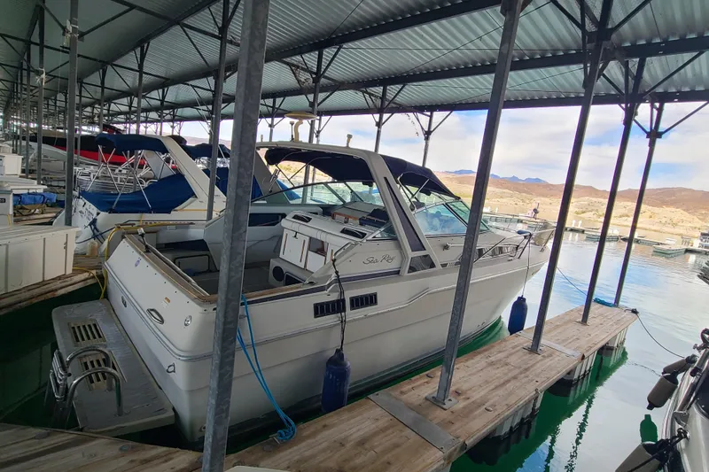 Slide: The Image of 1987 Sea Ray 300 Sundancer docked in a marina under a metal canopy. - 3