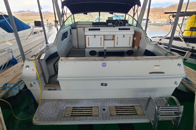 Slide: The Image of 1987 Sea Ray 300 Sundancer docked, showcasing spacious deck and cabin area. - 4