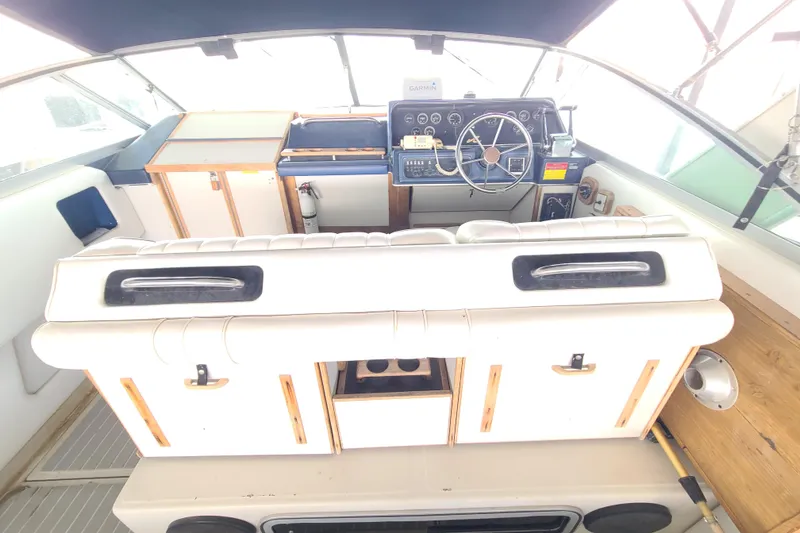 Slide: The Image of 1987 Sea Ray 300 Sundancer cockpit with steering wheel, gauges, and white seating. - 6