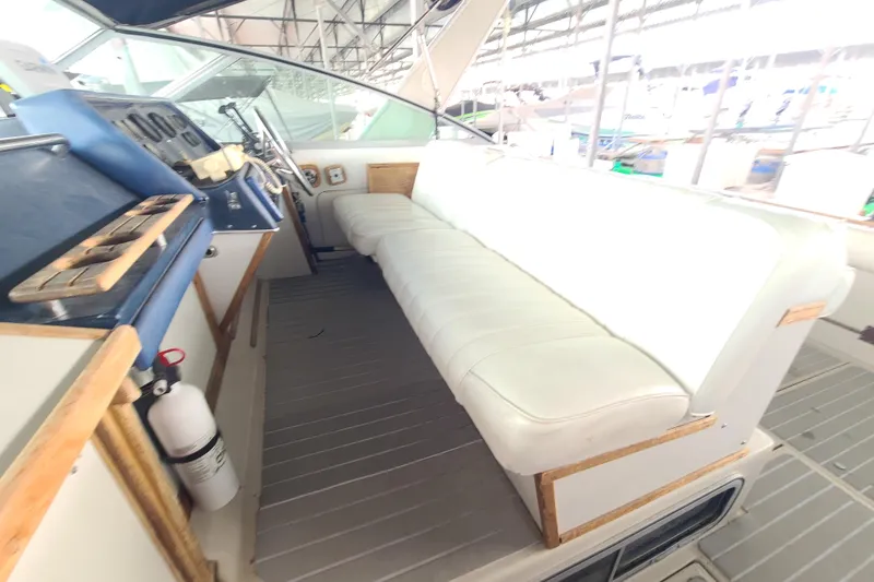 Slide: The Image of 1987 Sea Ray 300 Sundancer cockpit with white seating and control panel. - 7
