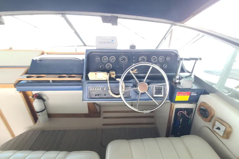 Slide: The Image of 1987 Sea Ray 300 Sundancer helm with steering wheel, gauges, and Garmin device. - 8