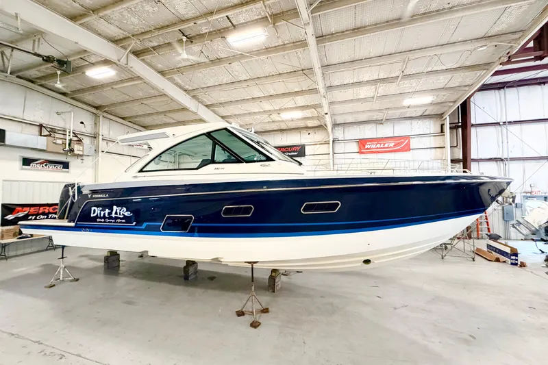 The Image of 2023 Formula 380 Super Sport Crossover OB boat in a spacious indoor showroom. - 0