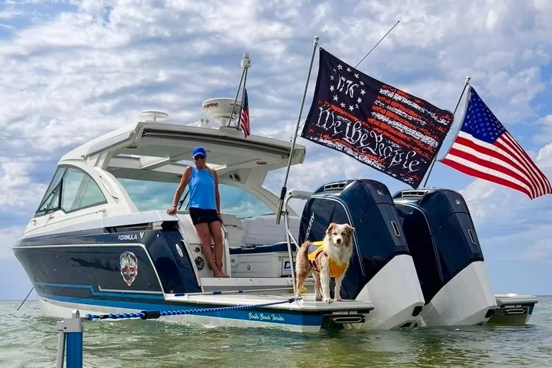 Slide: The Image of 2023 Formula 380 Super Sport Crossover OB with flags and a dog on board. - 35