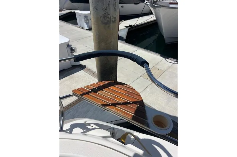 Slide: The Image of Hunter 430 sailboat cockpit detail with wooden seat and steering wheel, docked at marina. - 10
