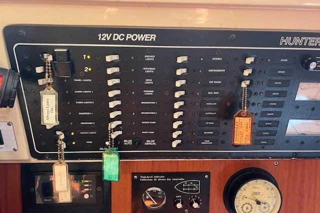 Slide: The Image of 12V DC power panel on 1997 Hunter 430 sailboat with labeled switches and gauges. - 21