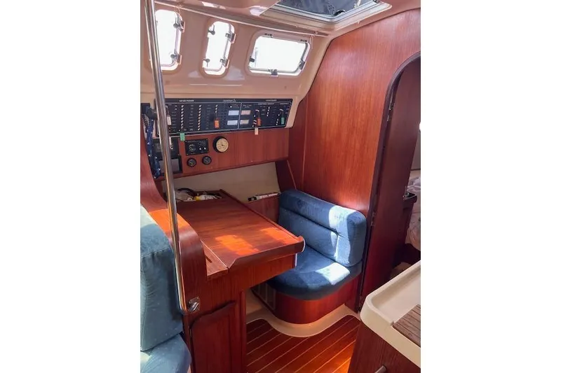 Slide: The Image of Interior of a 1997 Hunter 430 sailboat with wooden paneling and navigation station. - 30