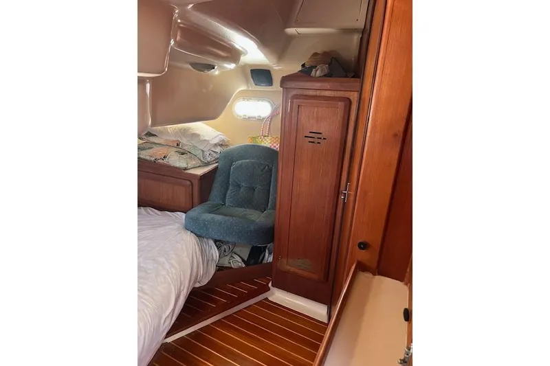 Slide: The Image of Interior of a 1997 Hunter 430 sailboat cabin with wooden finishes and cozy seating. - 32