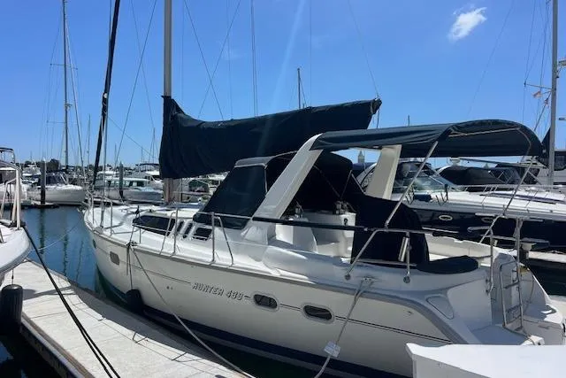 Slide: The Image of 1997 Hunter 430 sailboat docked at marina under clear blue sky. - 4