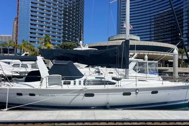 Slide: The Image of Sailboat Hunter 430, 1997 model, docked in a marina with modern buildings in the background. - 7