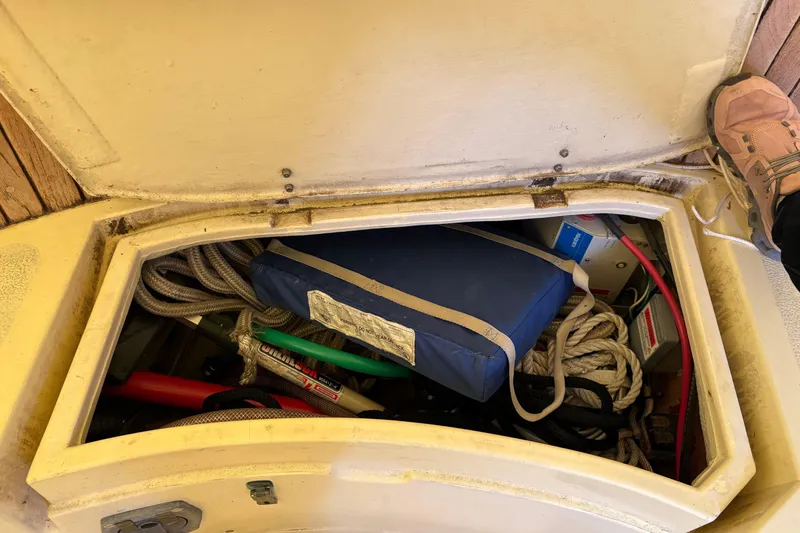 Slide: The Image of Storage compartment on a 1978 Pacific Seacraft 31 sailboat, containing ropes and equipment. - 12