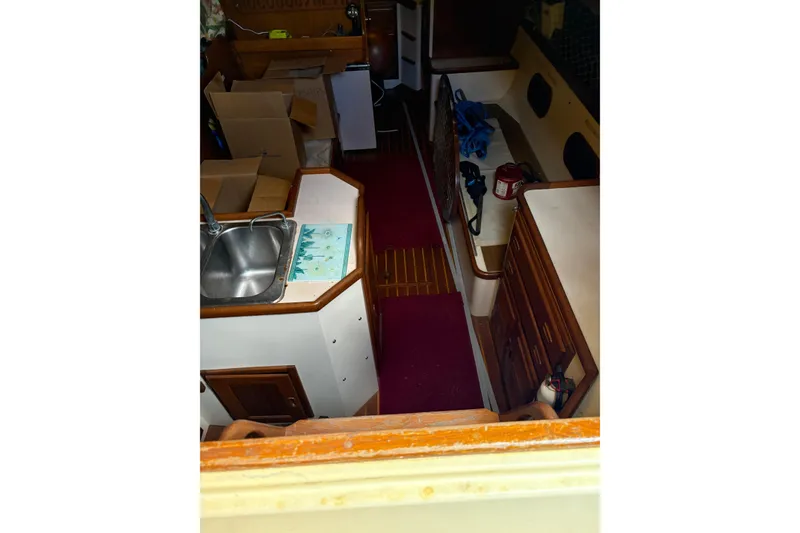 Slide: The Image of Interior of 1978 Pacific Seacraft 31 sailboat with sink, cabinets, and red carpet. - 14