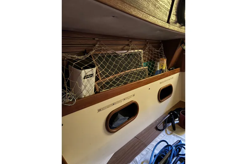 Slide: The Image of Interior of a 1978 Pacific Seacraft 31 sailboat with storage netting and nautical equipment. - 19