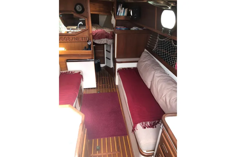 Slide: The Image of Interior of a 1978 Pacific Seacraft 31 sailboat with cozy seating and wooden finishes. - 2