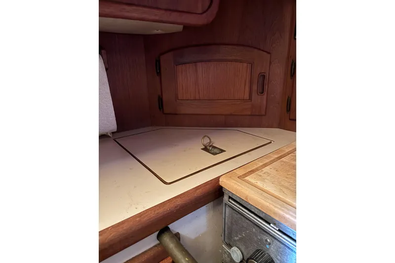 Slide: The Image of Interior of a 1978 Pacific Seacraft 31 sailboat, featuring wooden cabinetry and a countertop. - 21