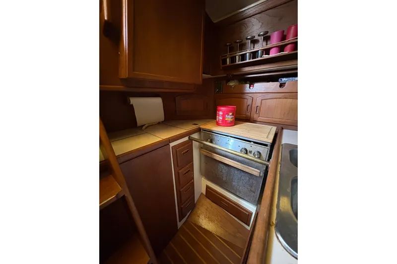 Slide: The Image of Cozy galley kitchen in 1978 Pacific Seacraft 31 sailboat with wooden cabinetry and compact stove. - 23