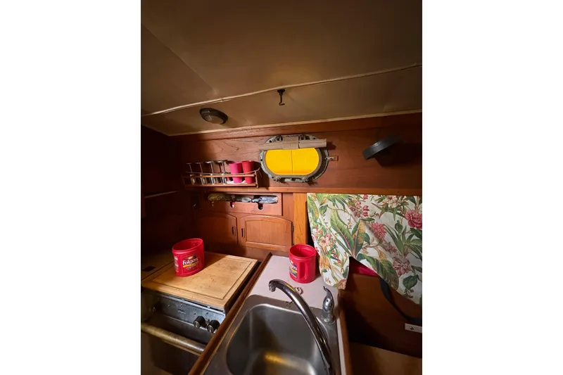 Slide: The Image of Interior of 1978 Pacific Seacraft 31 sailboat galley with sink, storage, and decor. - 24