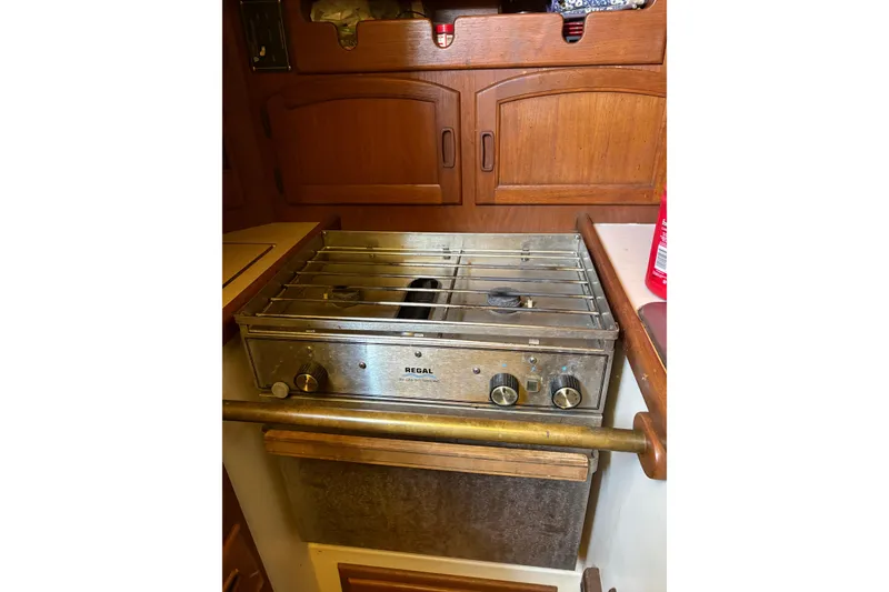 Slide: The Image of Galley stove in 1978 Pacific Seacraft 31 sailboat kitchen, featuring wooden cabinetry. - 25