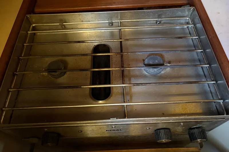 Slide: The Image of Vintage stove on a 1978 Pacific Seacraft 31 sailboat, featuring dual burners and metal grates. - 26