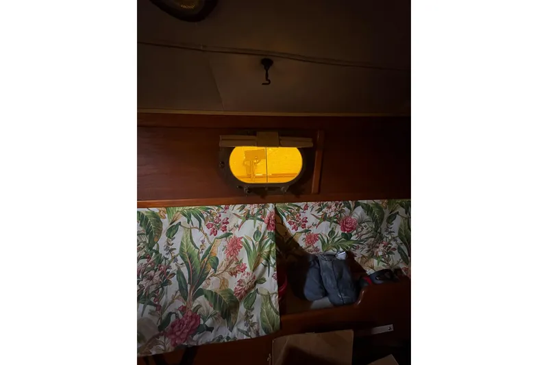 Slide: The Image of Interior of 1978 Pacific Seacraft 31 sailboat with floral curtains and porthole view. - 28