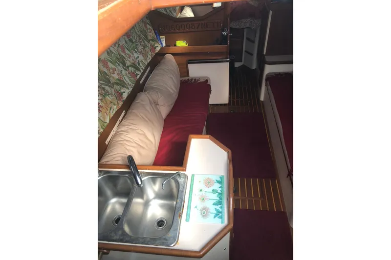 Slide: The Image of Interior of a 1978 Pacific Seacraft 31 sailboat with cozy seating and a compact kitchen sink. - 3