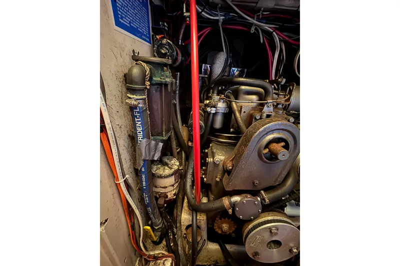 Slide: The Image of Engine compartment of a 1978 Pacific Seacraft 31 sailboat, showing mechanical components and wiring. - 33
