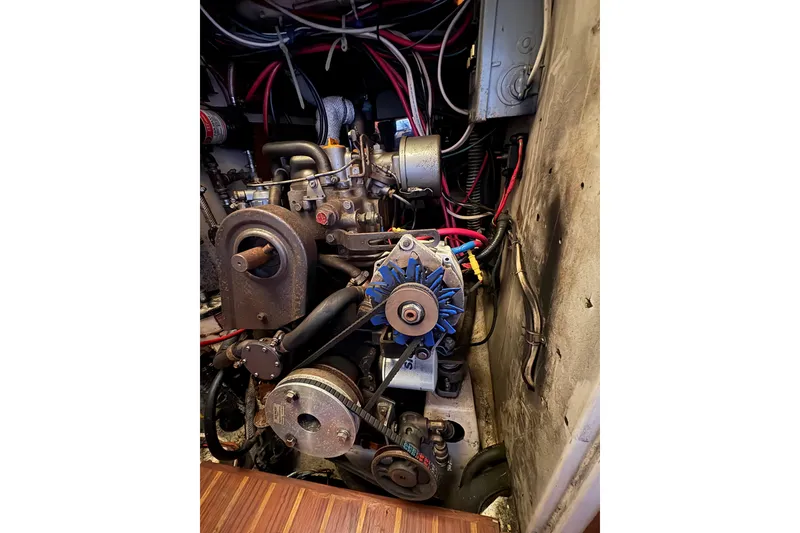Slide: The Image of Engine compartment of a 1978 Pacific Seacraft 31 sailboat, showcasing mechanical components and wiring. - 34