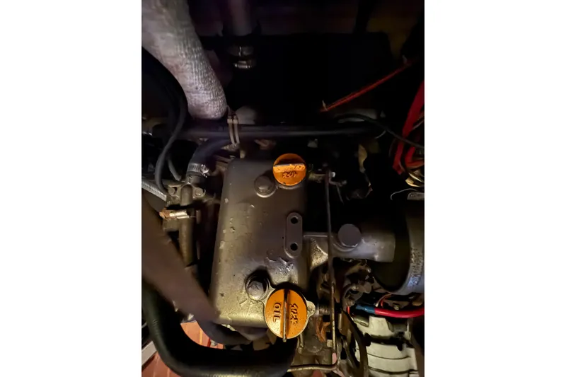 Slide: The Image of Engine compartment of a 1978 Pacific Seacraft 31 sailboat, showing oil caps and hoses. - 35