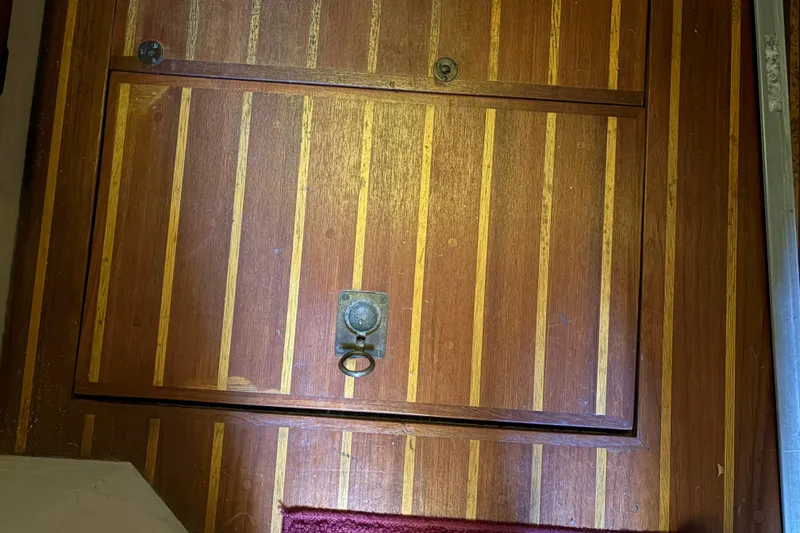 Slide: The Image of Wooden hatch door on 1978 Pacific Seacraft 31 sailboat, featuring brass handle and striped design. - 36