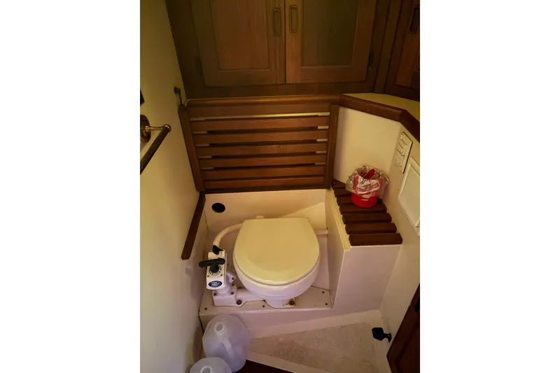 Slide: The Image of 1978 Pacific Seacraft 31 yacht bathroom with wooden accents and compact toilet. - 41