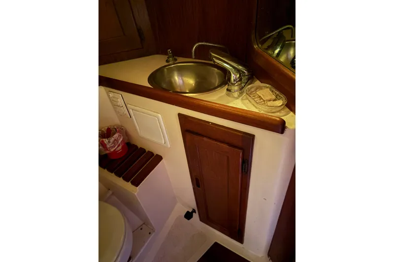 Slide: The Image of 1978 Pacific Seacraft 31 yacht bathroom with sink, faucet, and wooden cabinetry. - 42